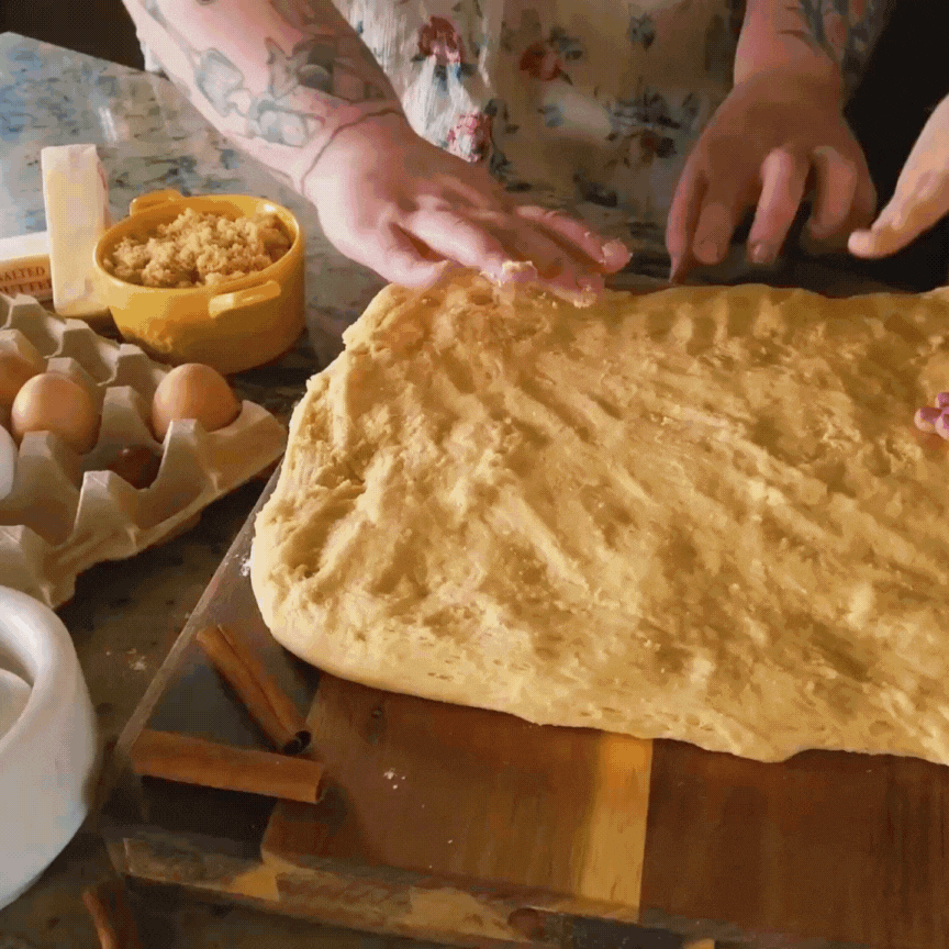 baker and daughter make cinnamon rolls in kitchen