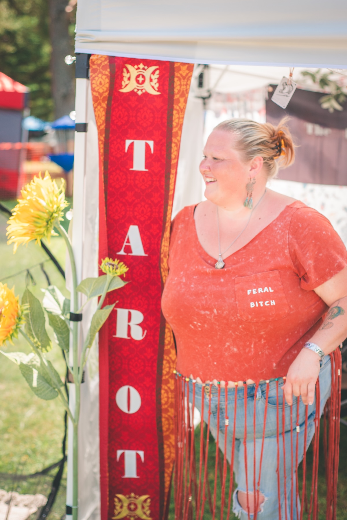 woman stands beside a tarot card banner