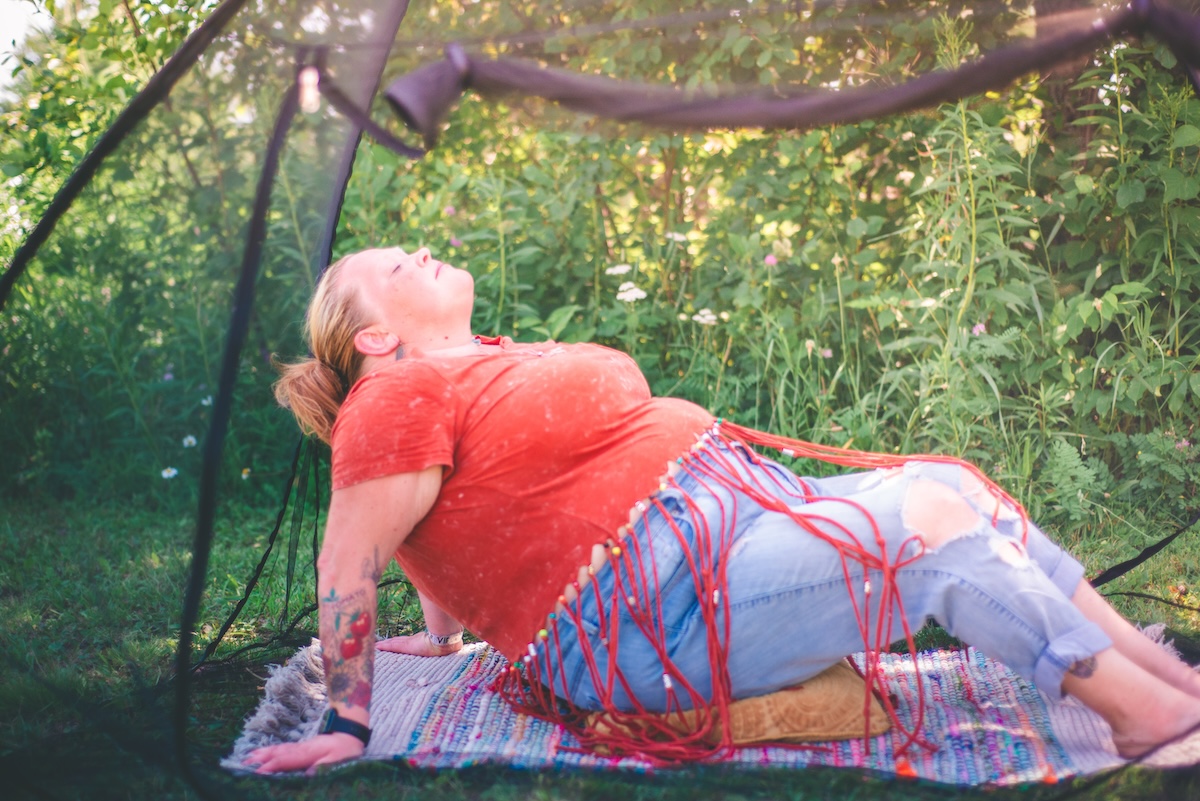 woman meditates in a mesh tent