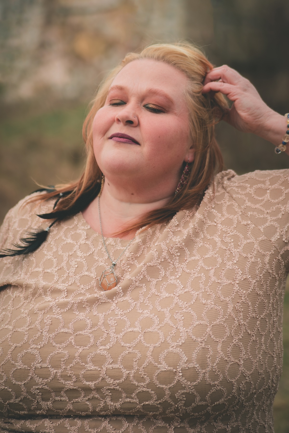 woman brushes hand through hair outdoors