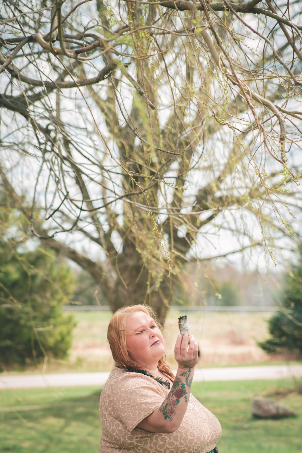 woman smudges the air with sage outdoors