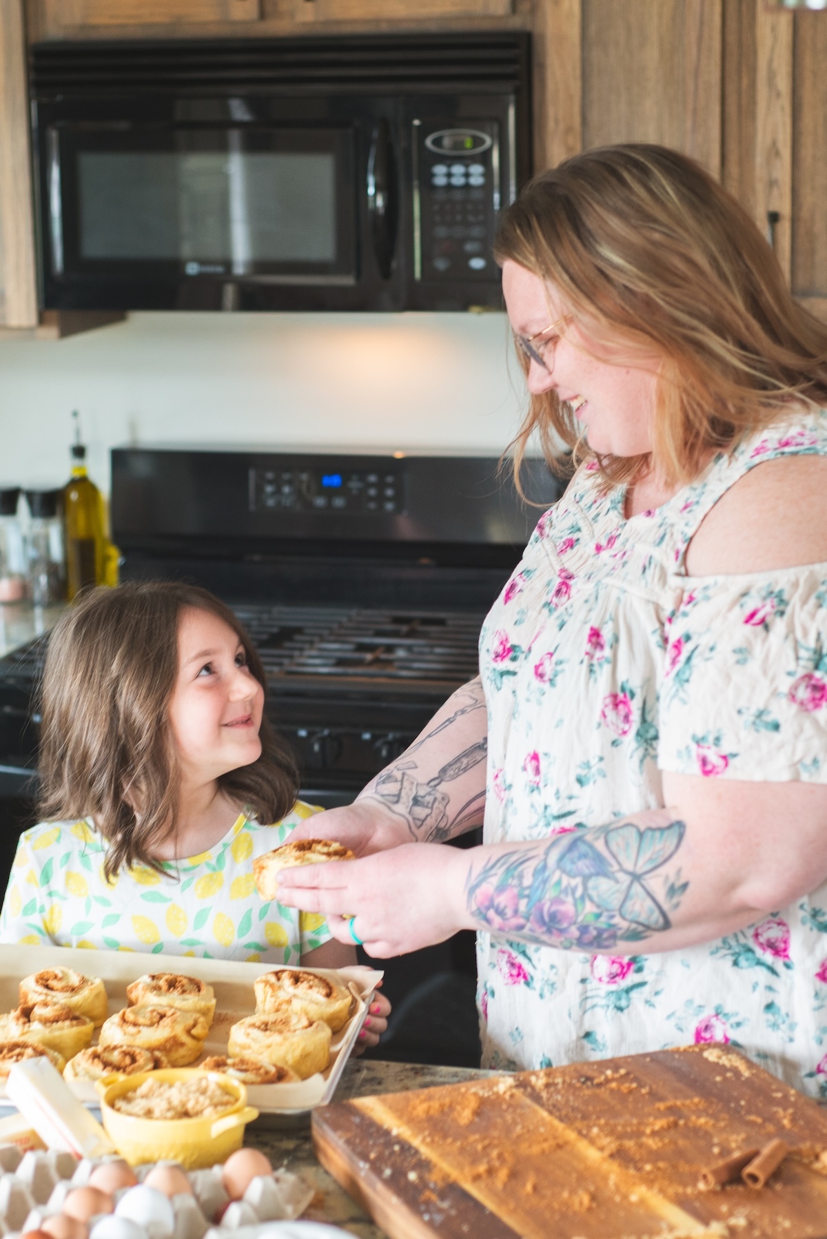 mom and daughter make cinnamon rolls in kitchen