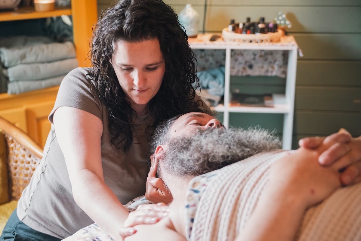 massage therapist massages mans neck and shoulder