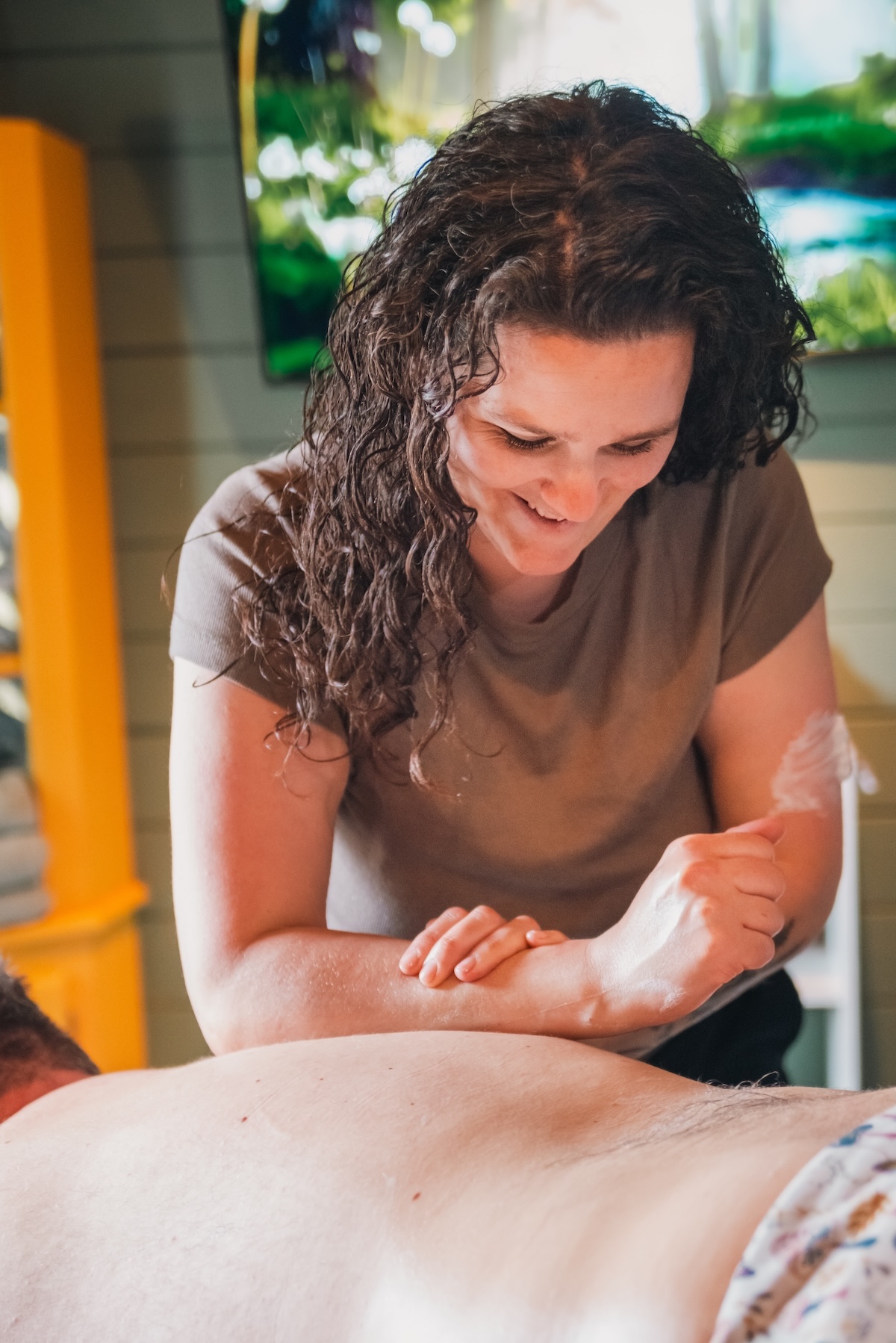 massage therapist uses her arm to work a knot