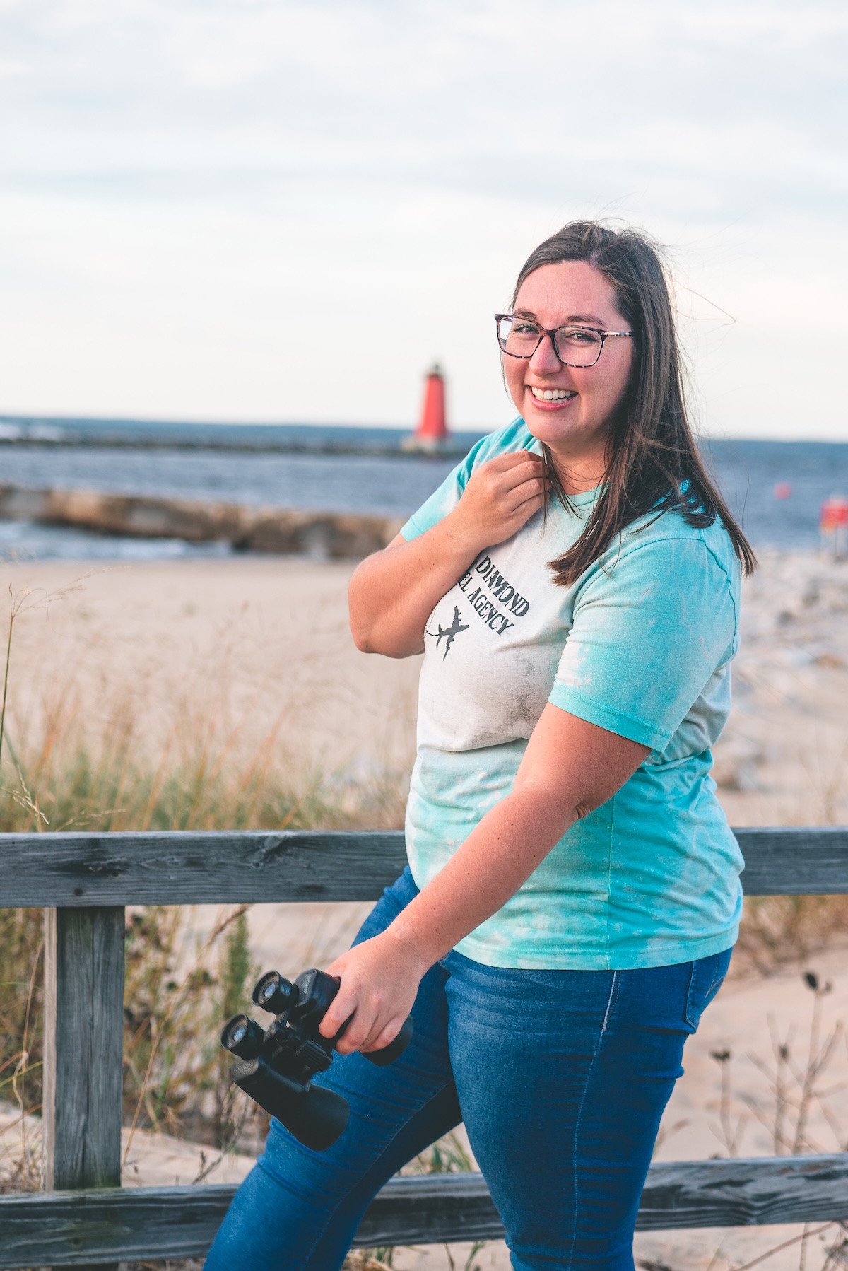 woman stands on beach with binoculars