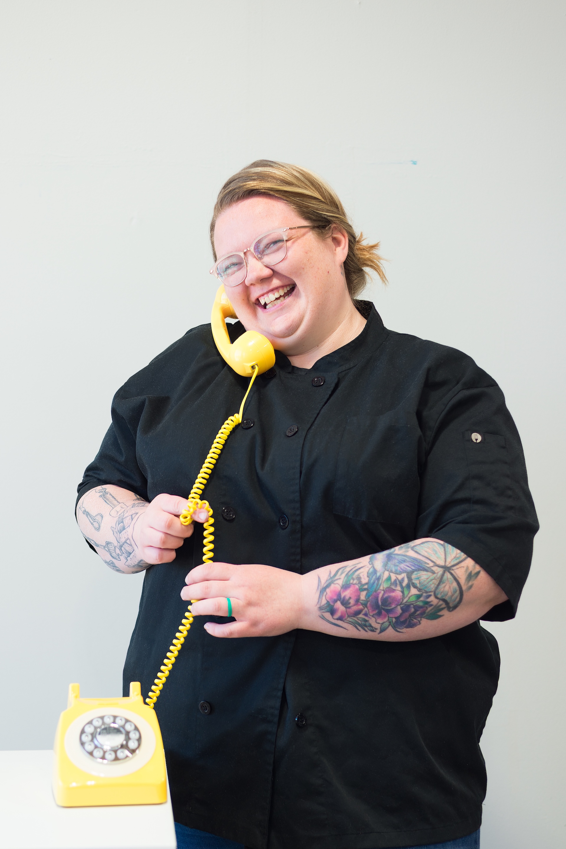 Brianna from The Cake Lady. & Co holds a cute butter yellow phone