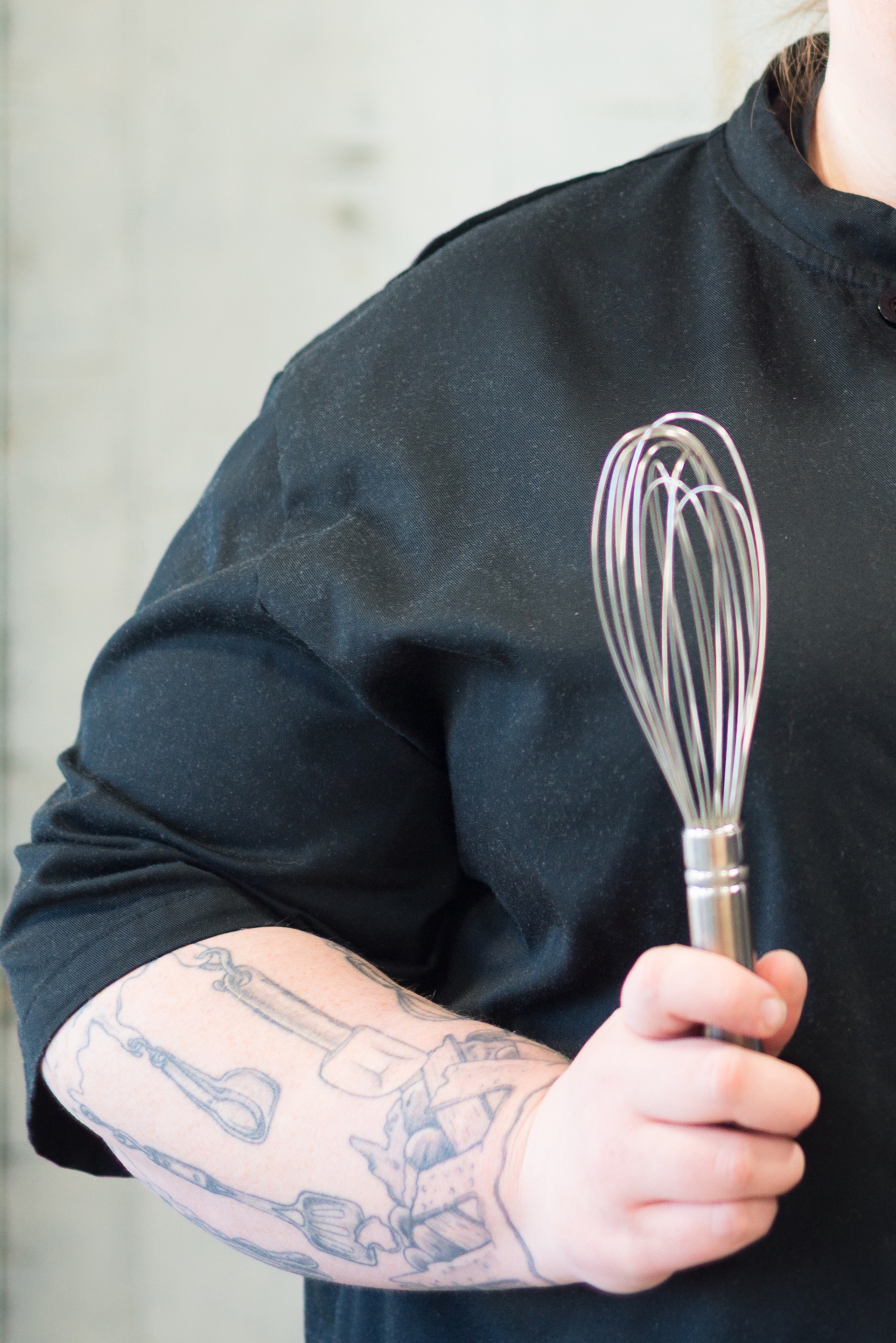 Close up of a wisk being held by a woman