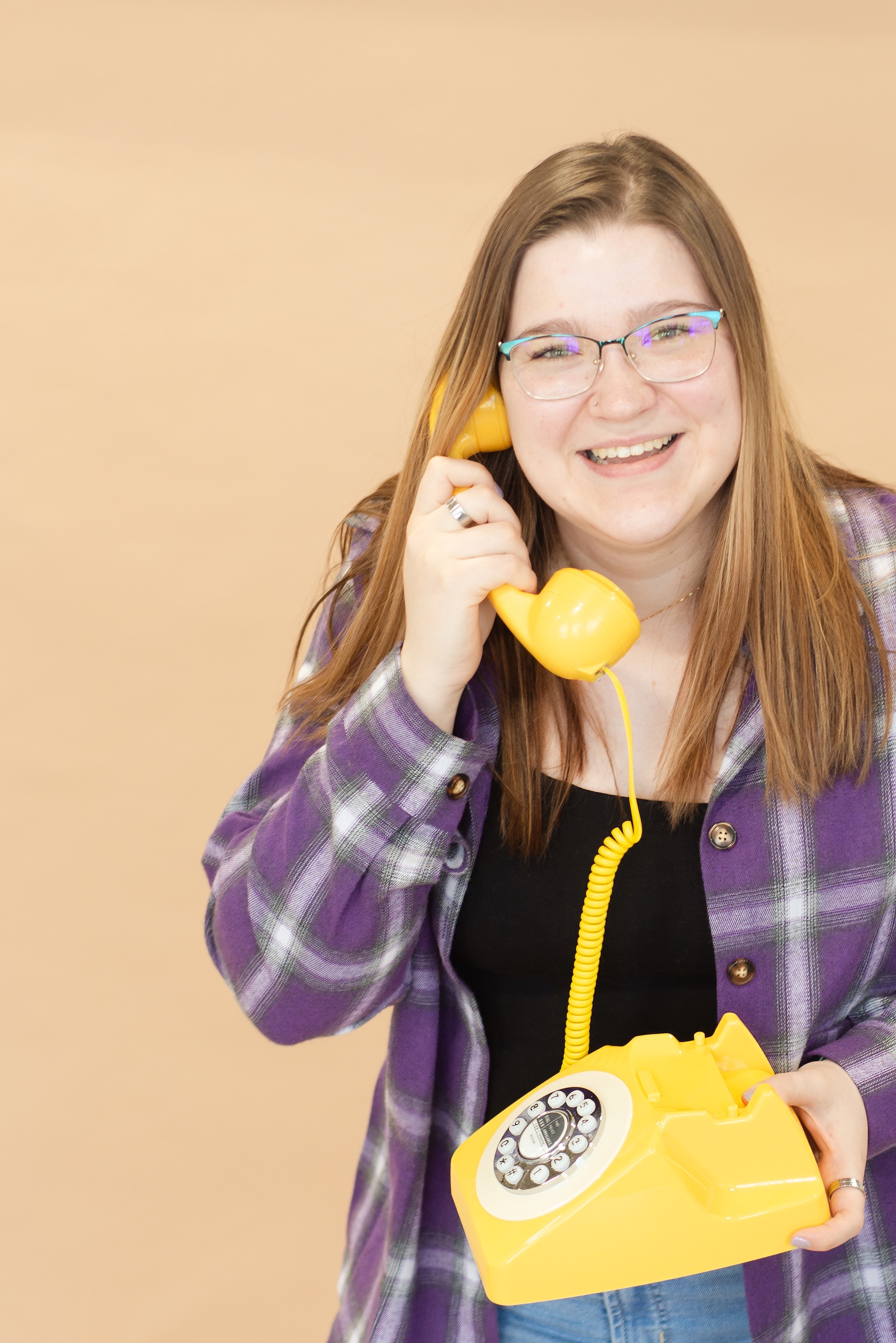 woman in purple answers a yellow phone