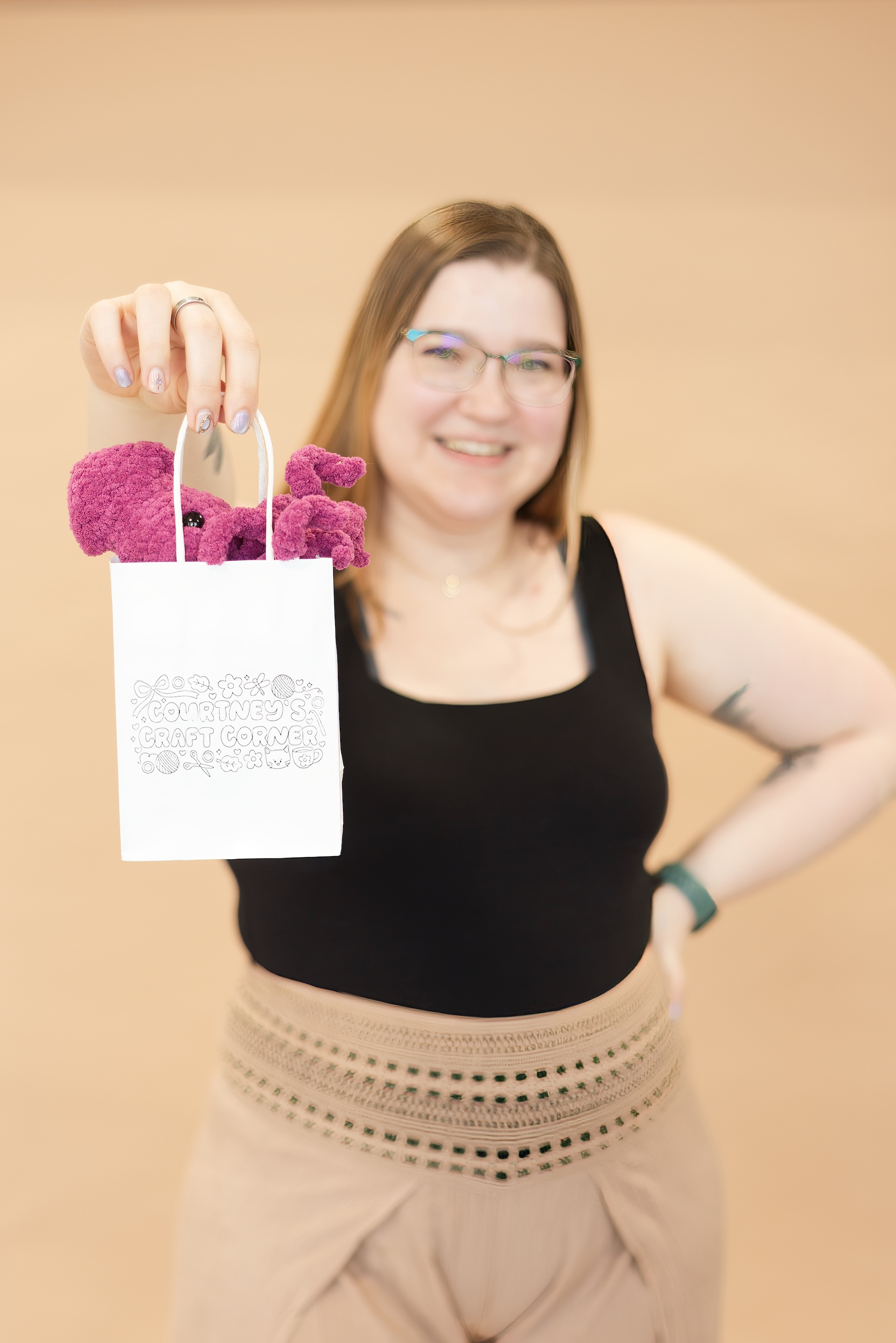 woman holds shopping bag with her craft business logo for Courtney's Craft Corner