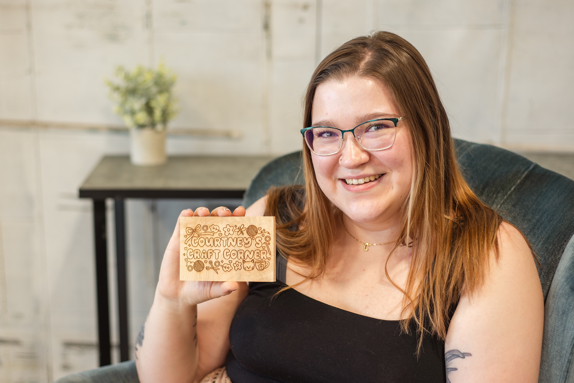 Courtney holds logo engraved on wood