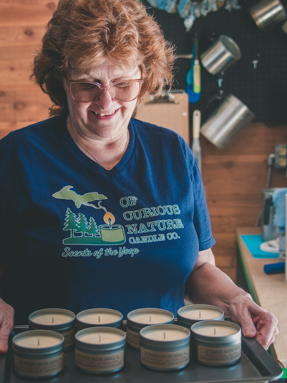 candle maker smiles down at her new batch of candles