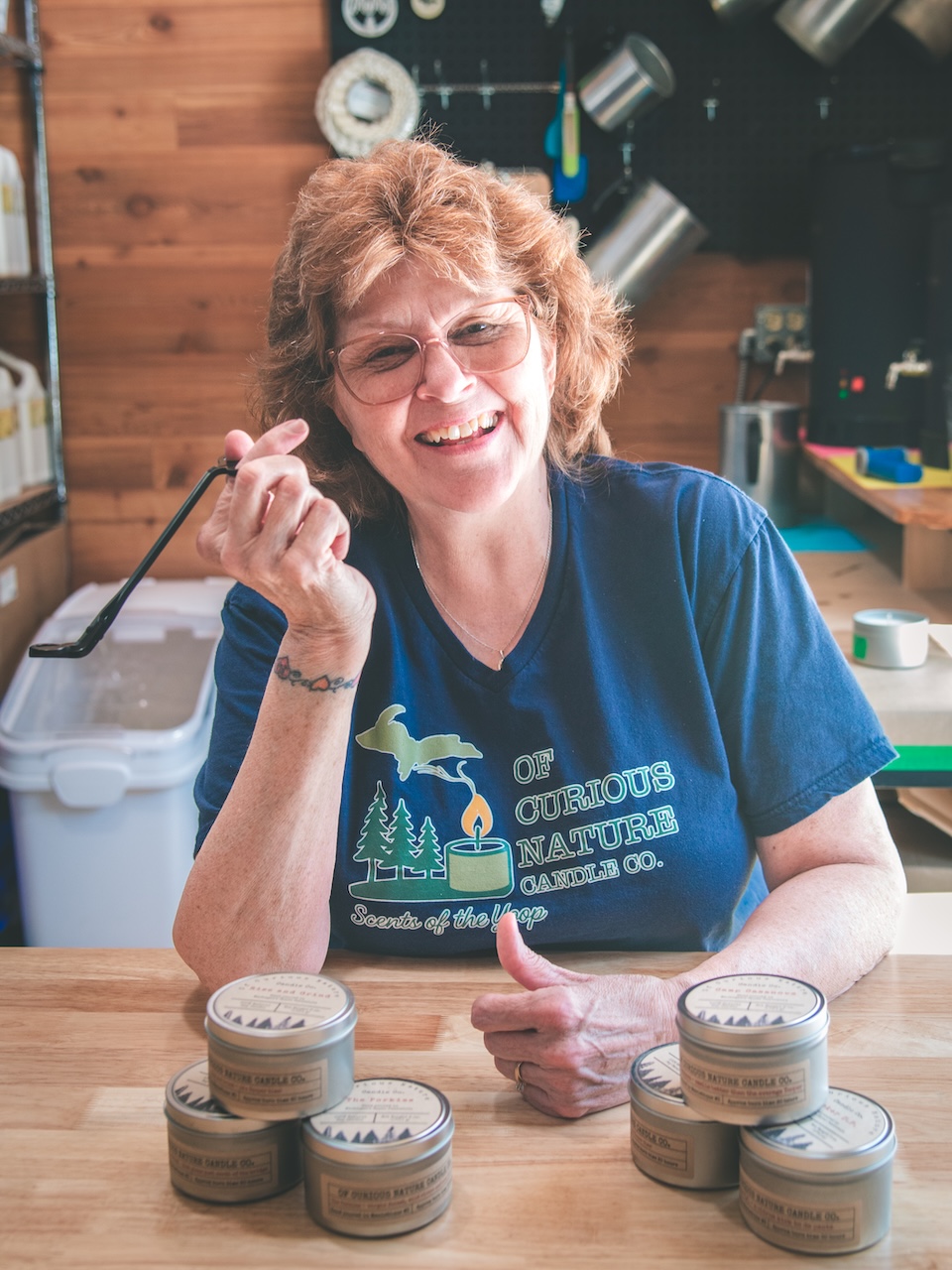 Candle maker lady hold wick cutter and laughs