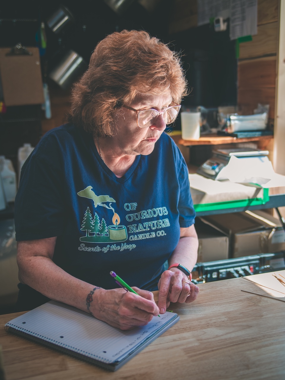 woman sits at desk and thoughtfully takes notes