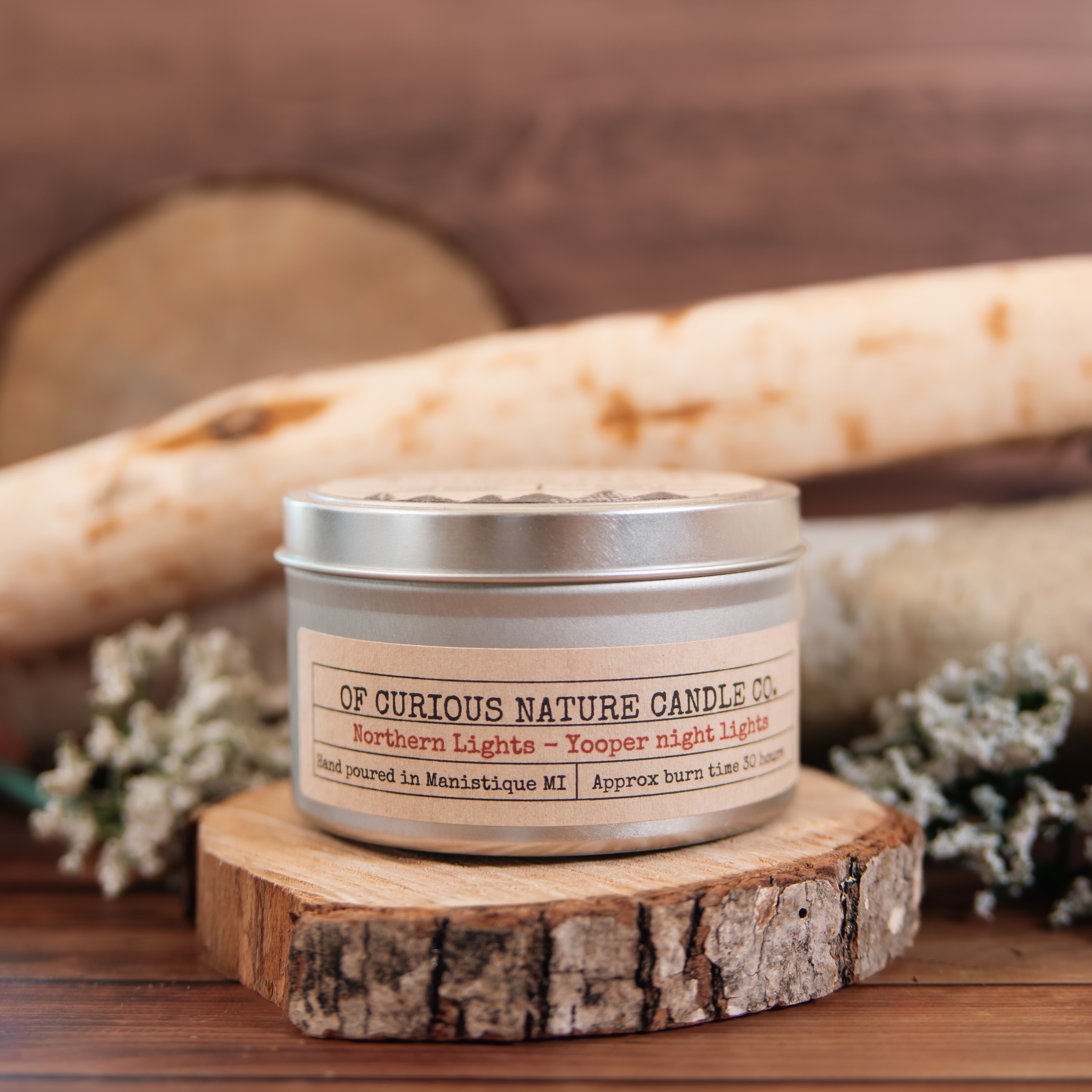 Upper Peninsula themed candle in front of a woodland scene