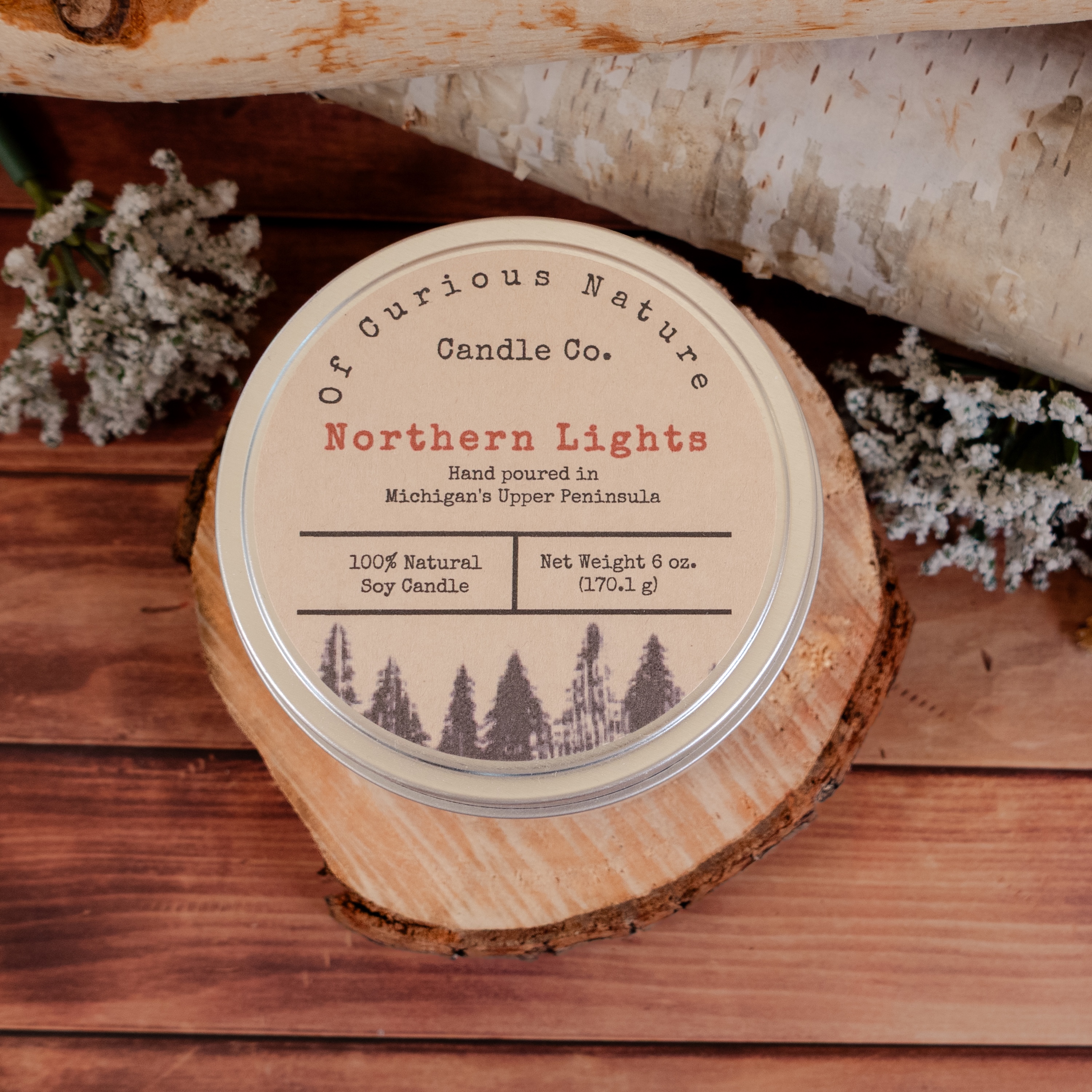 Upper Peninsula themed candle in front of a woodland scene