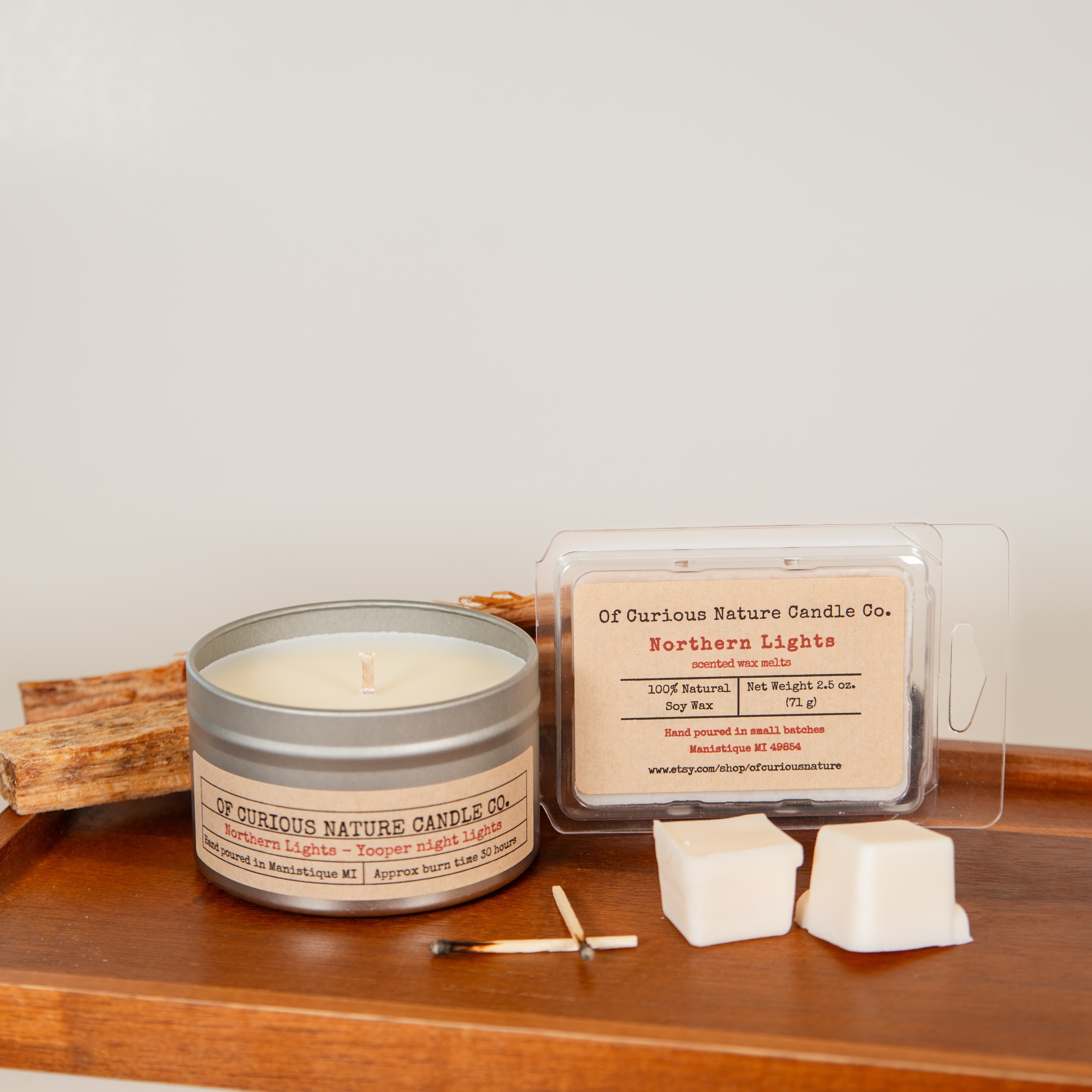 Upper Peninsula themed candle and wax melt sit on a tray in front of a white background