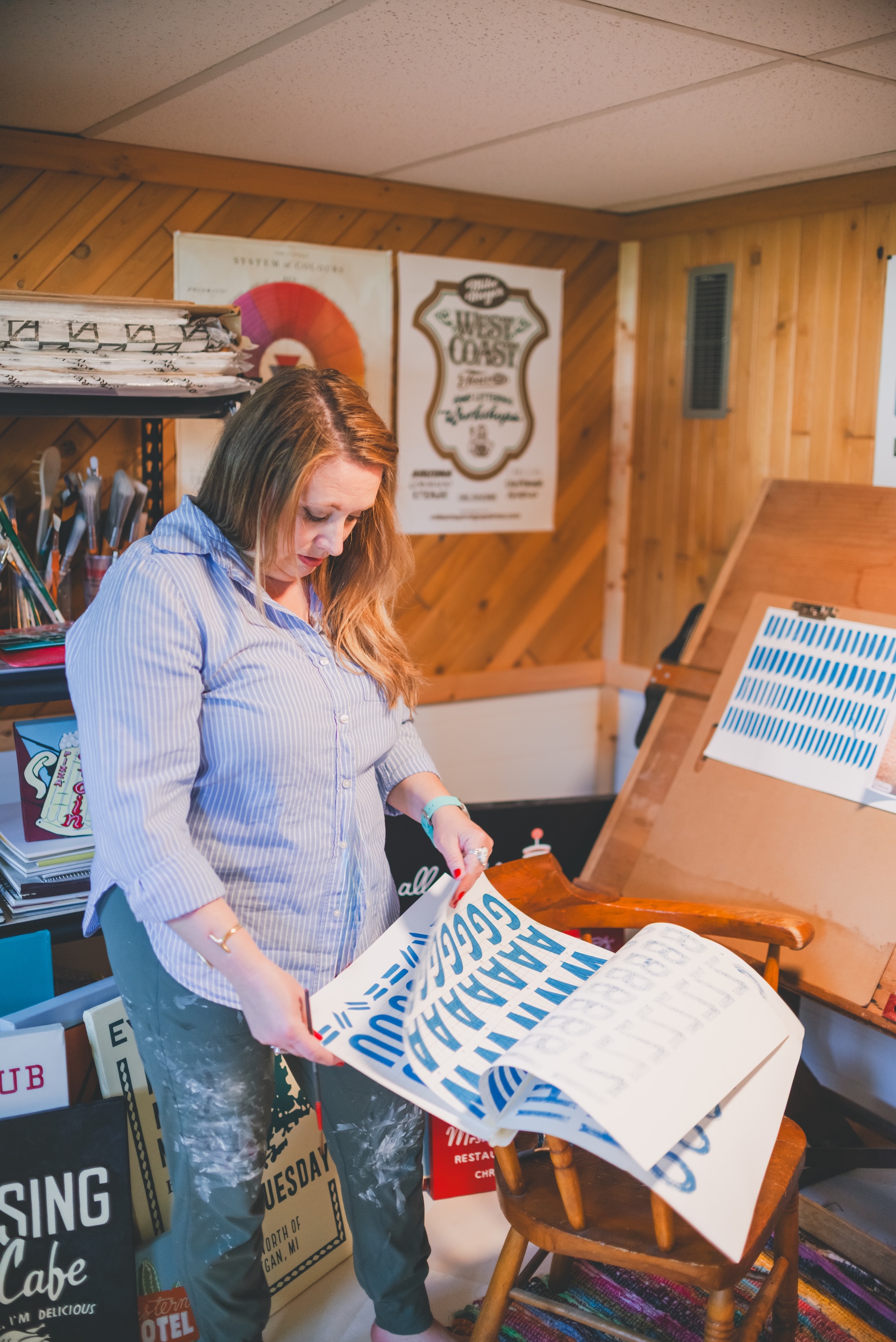 Jamie of Starsiding Studio studies hand painted lettering in her Munising MI art studio