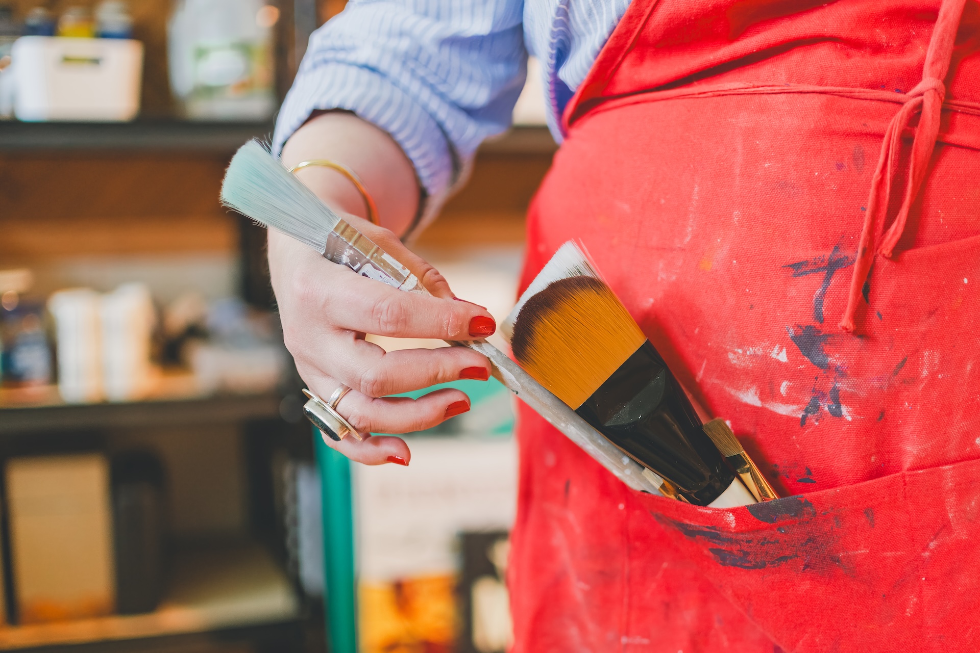 Close up of painter removing paintbrush from smock during a personal branding session