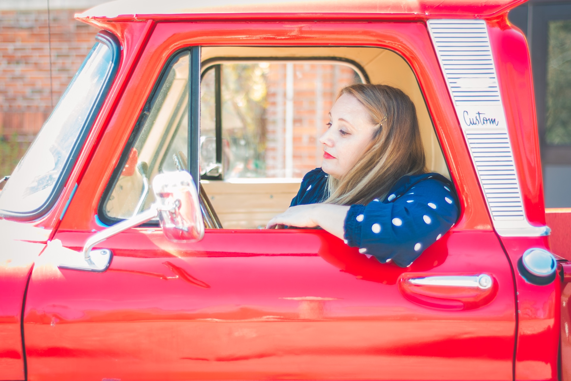 Michigan muralist Jamie posing with her vintage 1964 Chevy truck during a UP lifestyle branding photoshoot