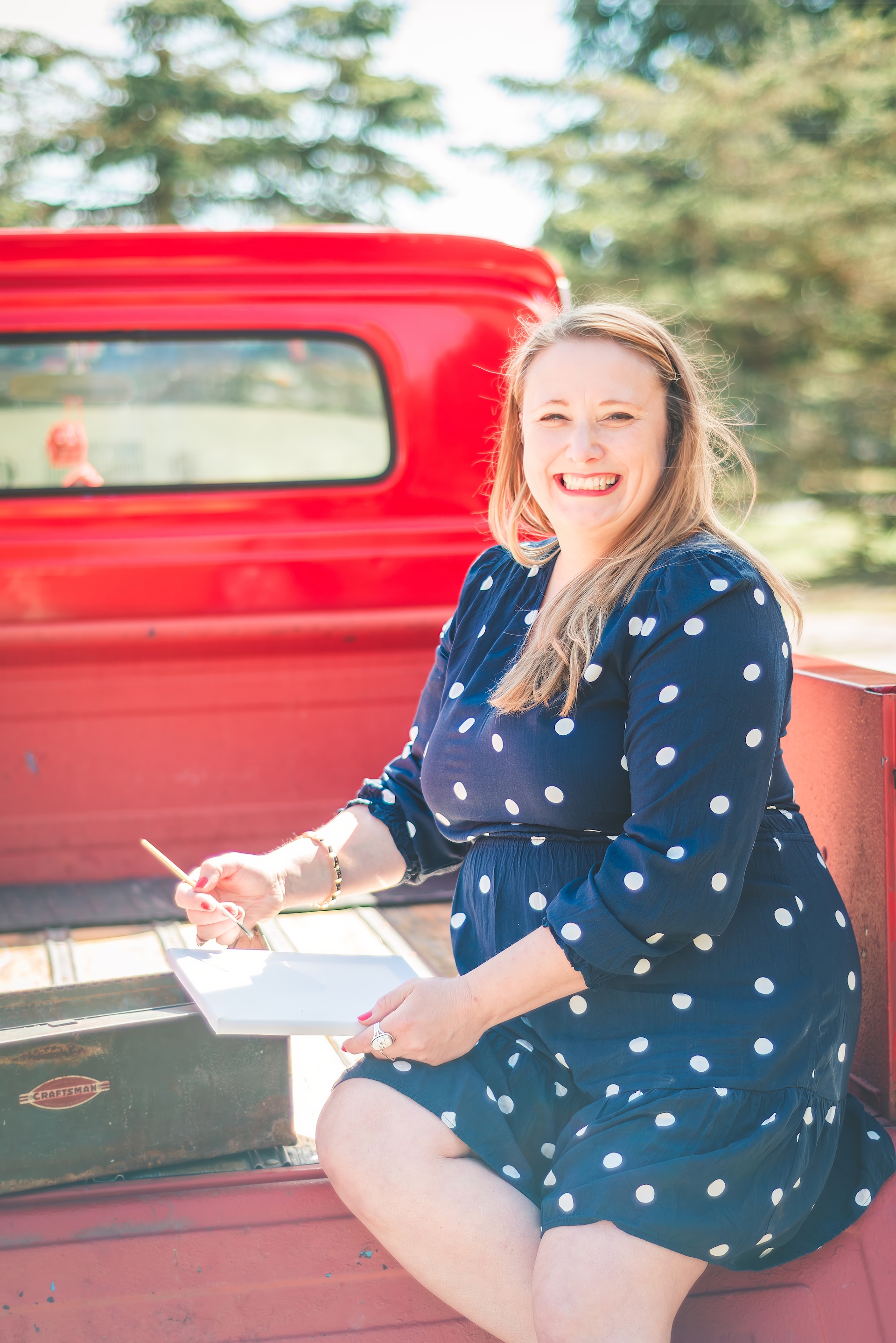 Michigan muralist Jamie posing with her vintage 1964 Chevy truck during a UP lifestyle branding photoshoot