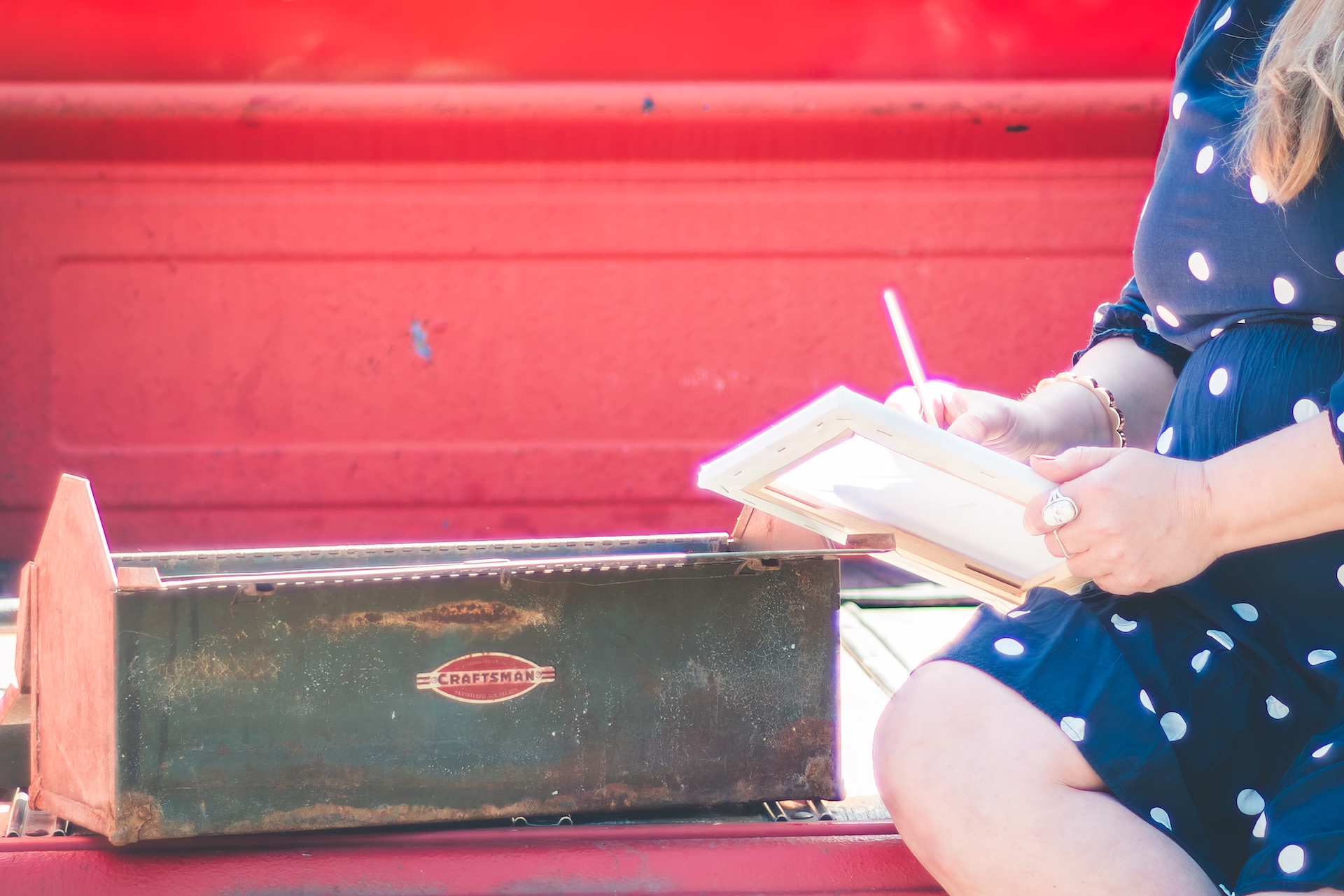 Close up of of paintbrush, polka dot dress, and vintage red truck during a personal branding session