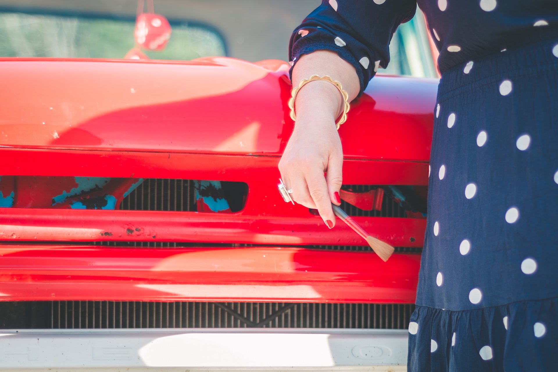 Close up of of paintbrush, polka dot dress, and vintage red truck during a personal branding session