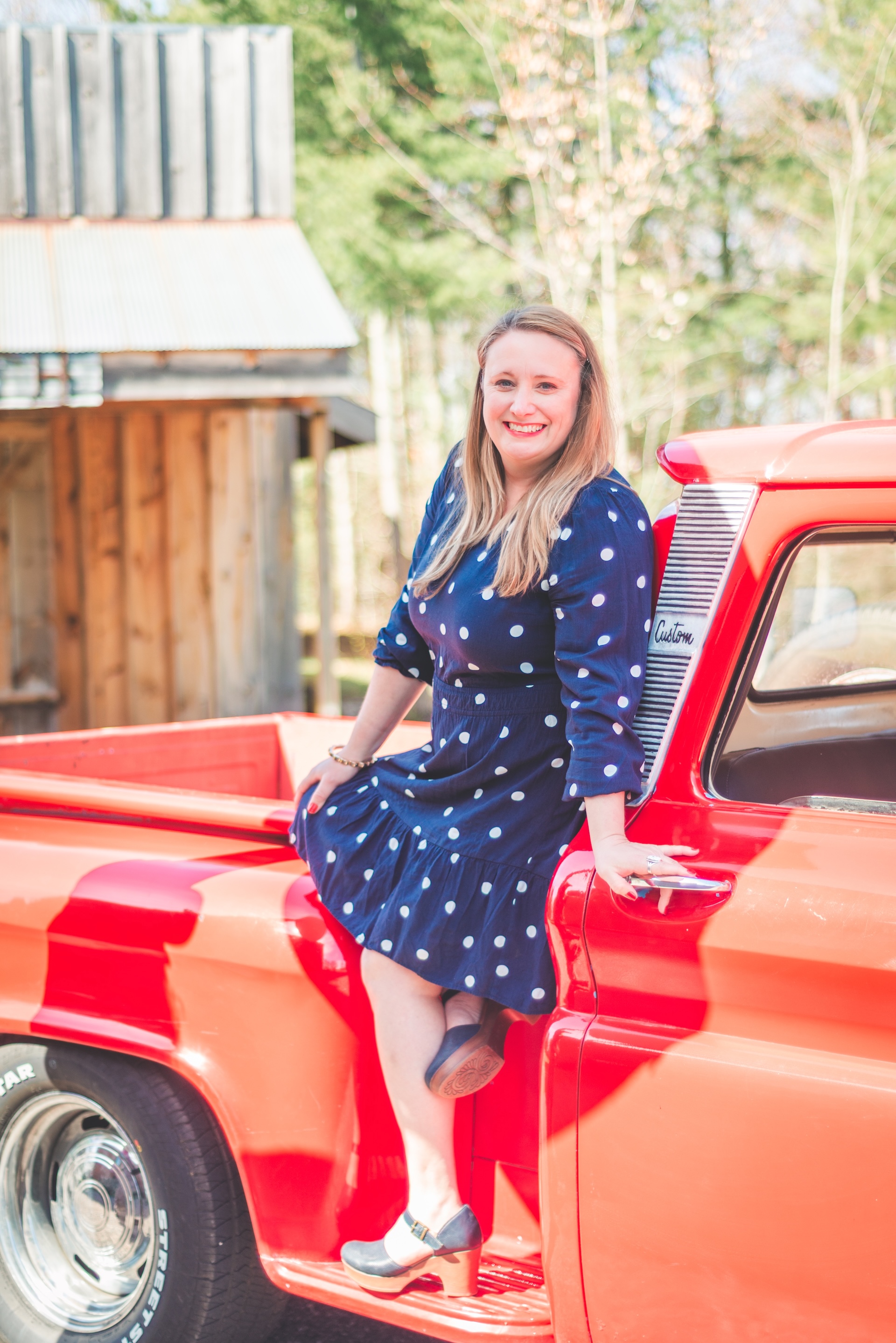 Michigan muralist Jamie posing with her vintage 1964 Chevy truck during a UP lifestyle branding photoshoot