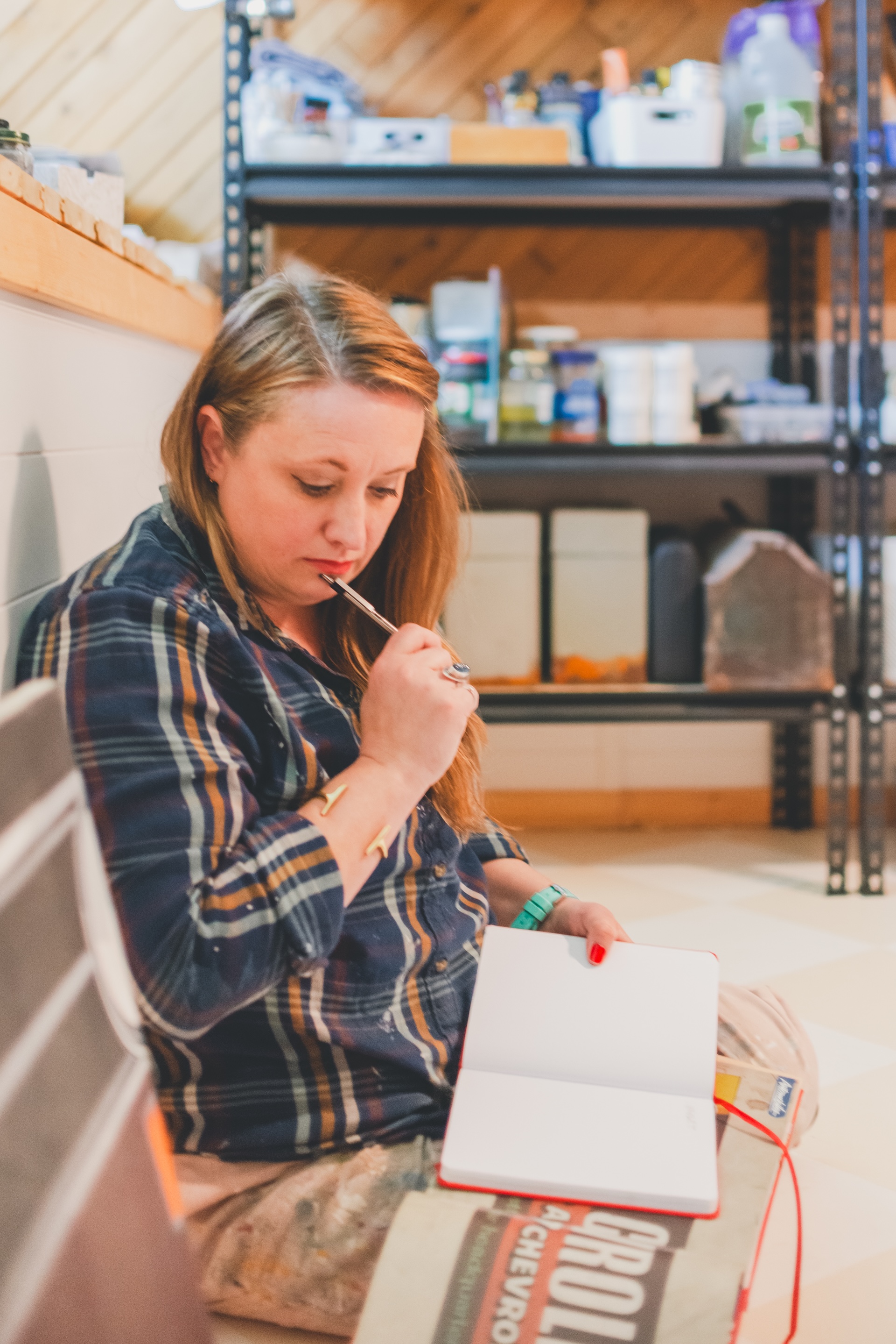 Jamie of Starsiding Studio works in her sketchbook in her Munising MI art studio